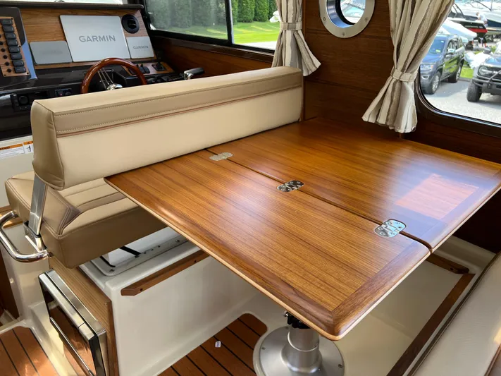  Yacht Photos Pics 2024 Ranger Tugs R-27 interior with wooden table and beige seating.