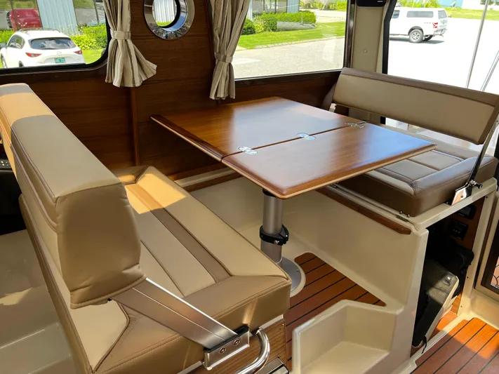  Yacht Photos Pics 2024 Ranger Tugs R-27 interior with wood table and beige seating.
