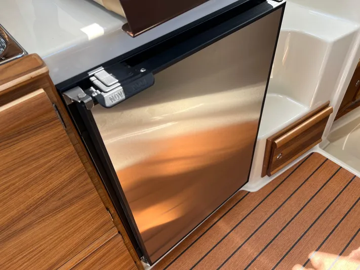  Yacht Photos Pics 2024 Ranger Tugs R-27 interior with stainless steel fridge and wood finish flooring.