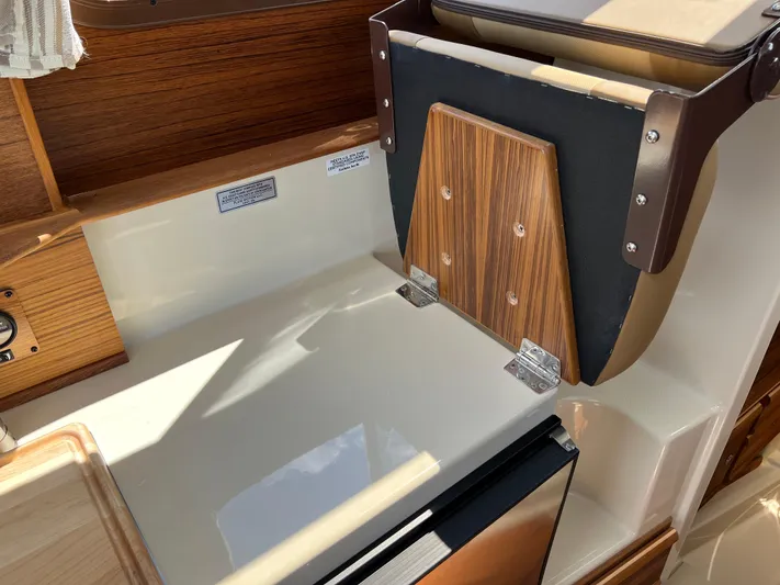  Yacht Photos Pics 2024 Ranger Tugs R-27 interior with wood accents and compact kitchen area.