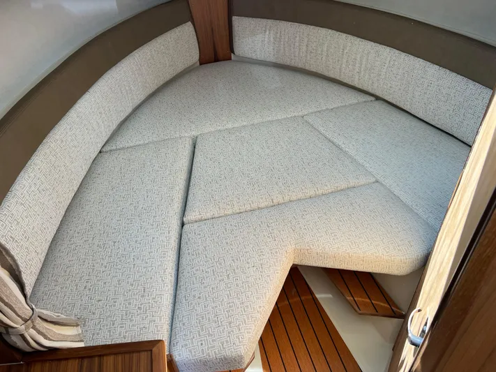  Yacht Photos Pics 2024 Ranger Tugs R-27 interior cabin with cushioned seating and wooden flooring.