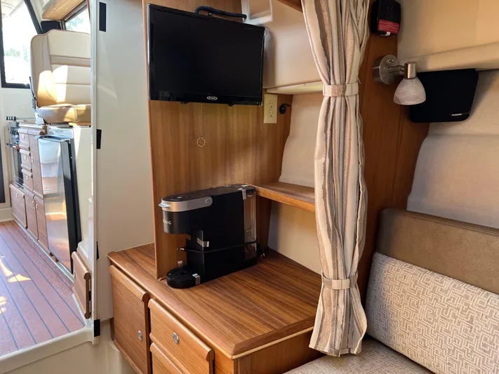  Yacht Photos Pics 2024 Ranger Tugs R-27 interior with TV, coffee maker, and wooden cabinetry.