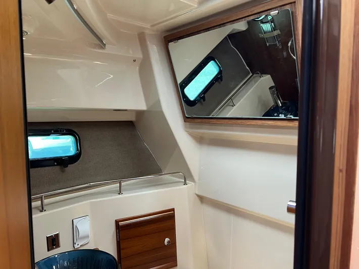  Yacht Photos Pics 2024 Ranger Tugs R-27 interior cabin with mirror and porthole window.