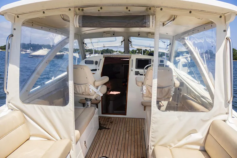 4652tw Yacht Photos Pics 2007 MJM 29z boat interior with helm, seating, and clear enclosures on the water.