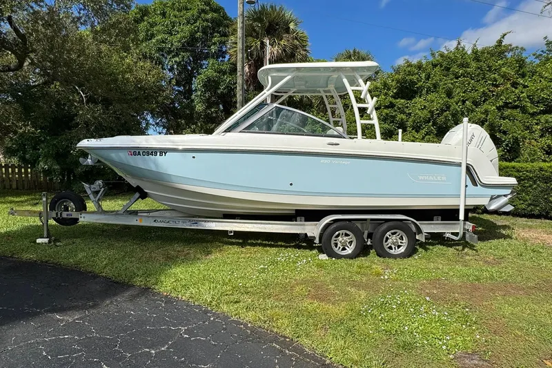  Yacht Photos Pics 2019 Boston Whaler 230 Vantage boat on trailer, parked on grass, sunny day.