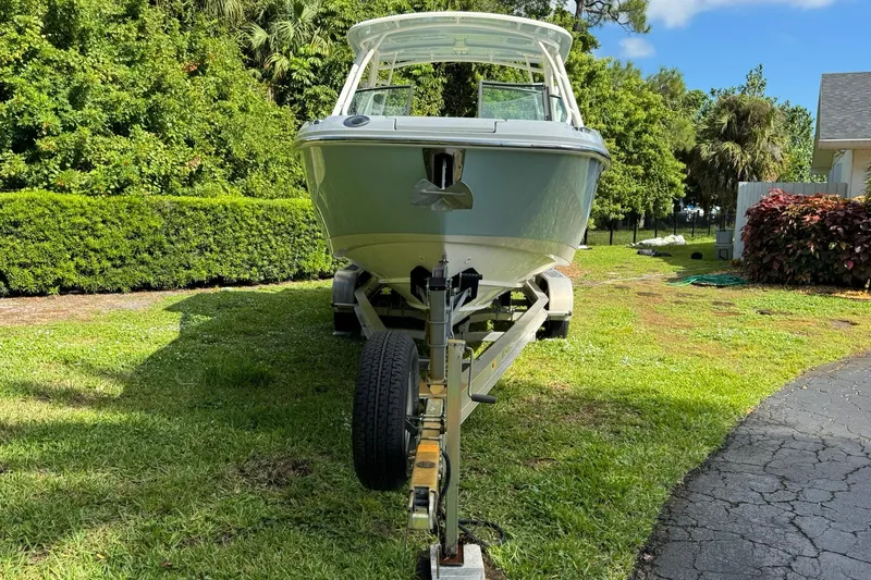  Yacht Photos Pics 2019 Boston Whaler 230 Vantage boat on trailer, parked on grassy area.
