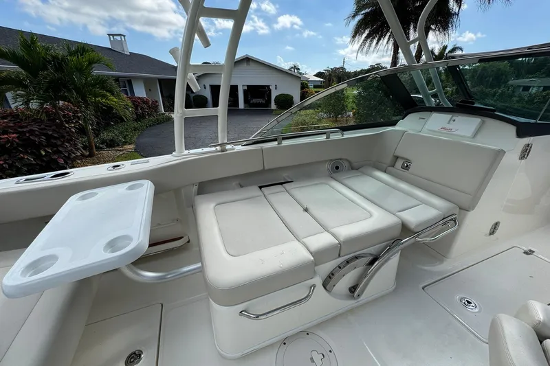  Yacht Photos Pics 2019 Boston Whaler 230 Vantage boat interior with seating and table, parked near a house.