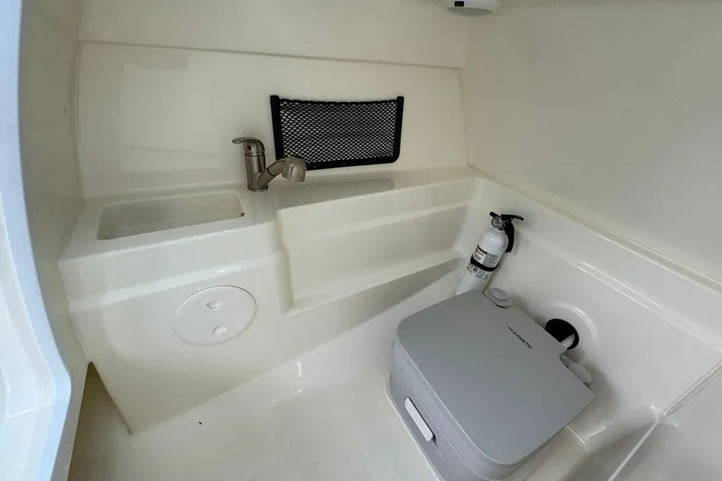  Yacht Photos Pics 2019 Boston Whaler 230 Vantage interior with sink, storage net, and portable toilet.