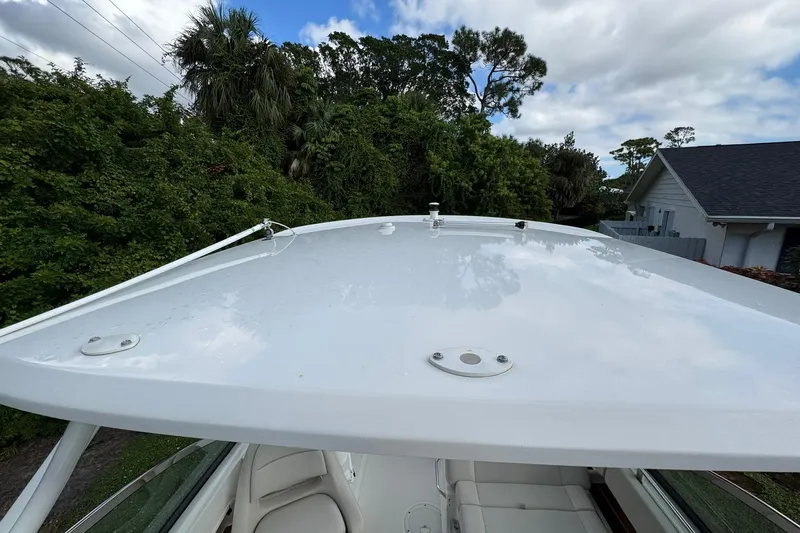  Yacht Photos Pics 2019 Boston Whaler 230 Vantage boat roof with lush greenery background.