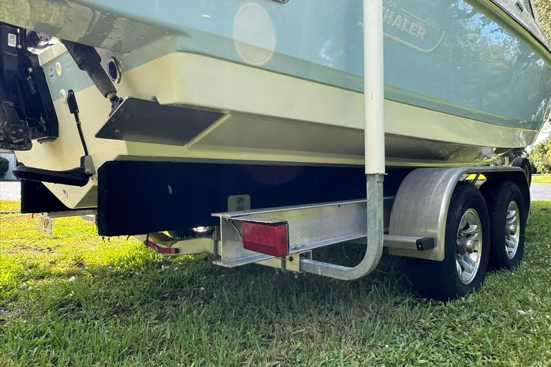  Yacht Photos Pics 2019 Boston Whaler 230 Vantage on trailer, rear view, parked on grass.