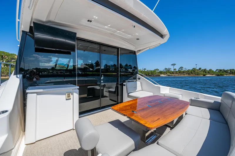  Yacht Photos Pics 2020 Tiara Yachts C53 Coupe, luxurious outdoor seating, sleek design, waterfront view.