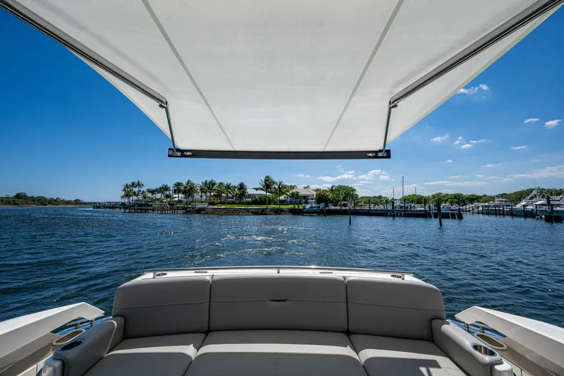 Yacht Photos Pics 2020 Tiara Yachts C53 Coupe, rear seating view, overlooking serene waterfront and blue sky.