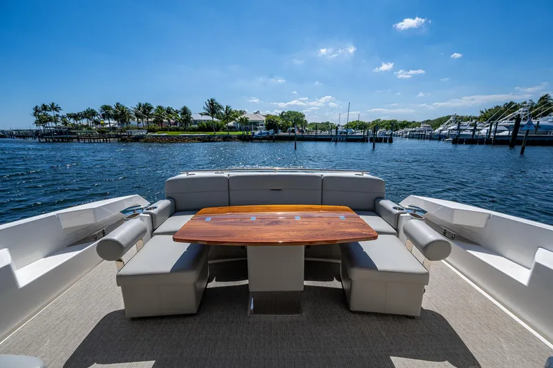 Yacht Photos Pics 2020 Tiara Yachts C53 Coupe deck with seating and table, overlooking serene waterfront.