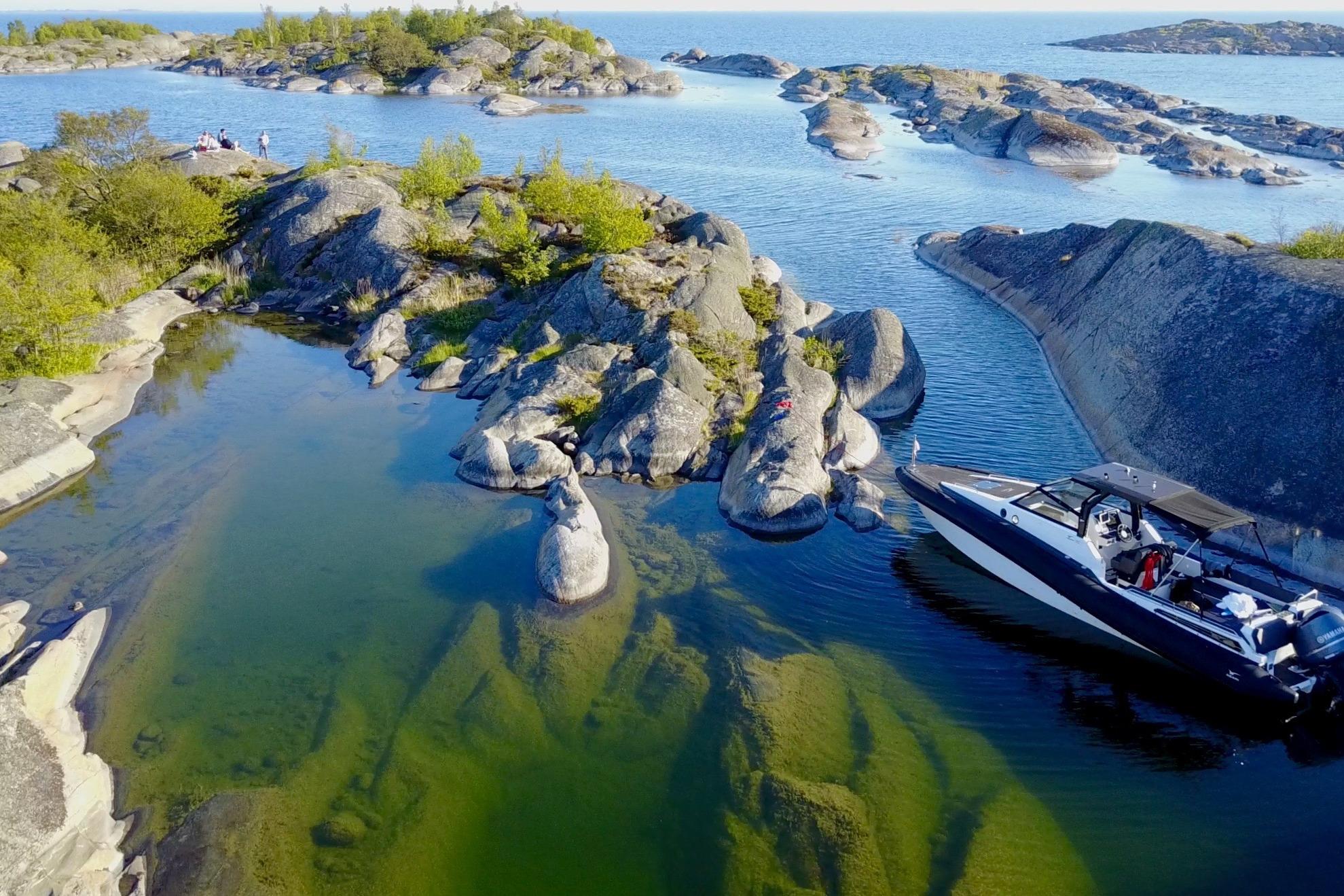 AGAPI 950 boat navigating rocky coastal waters, 2026 model, surrounded by scenic islands.