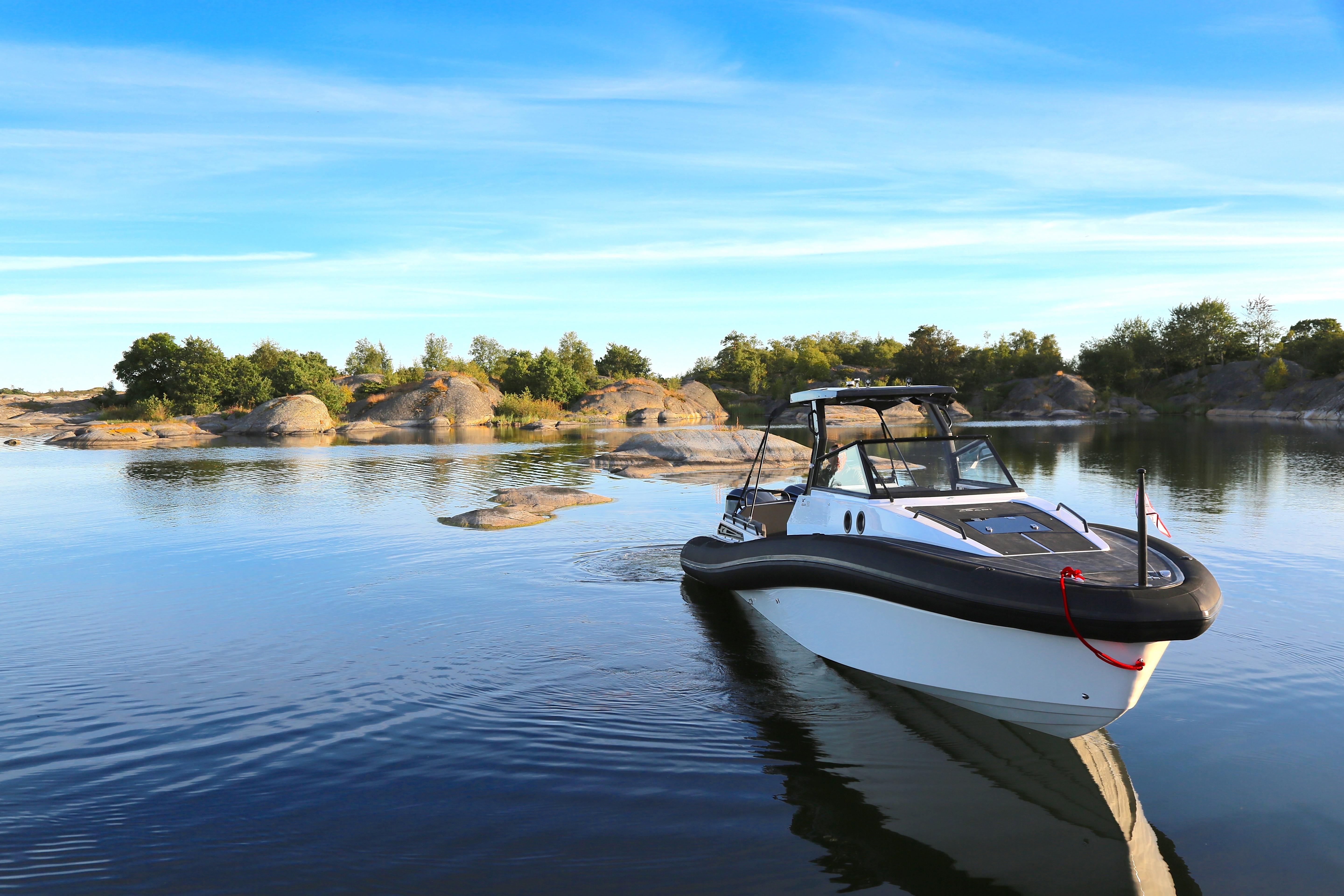 AGAPI 950 boat on serene water with rocky shoreline, 2026 model.