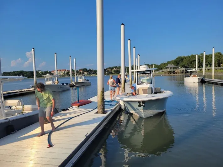  Yacht Photos Pics 2022 Tidewater 256 LXF boat docked at marina with people on pier.