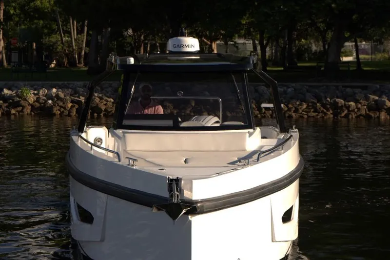  Yacht Photos Pics Front view of 2026 Fabbro F33 boat on calm water near rocky shore.