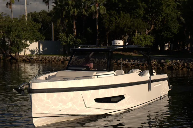  Yacht Photos Pics Modern Fabbro F33 boat from 2026 on calm water, surrounded by lush greenery.