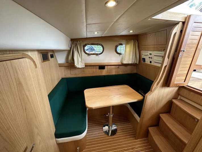 Fratelli Aprea Sorrento 32 Yacht Photos Pics Interior of 2023 Fratelli Aprea Sorrento Cabinatto 32 with wooden furnishings and green seating.