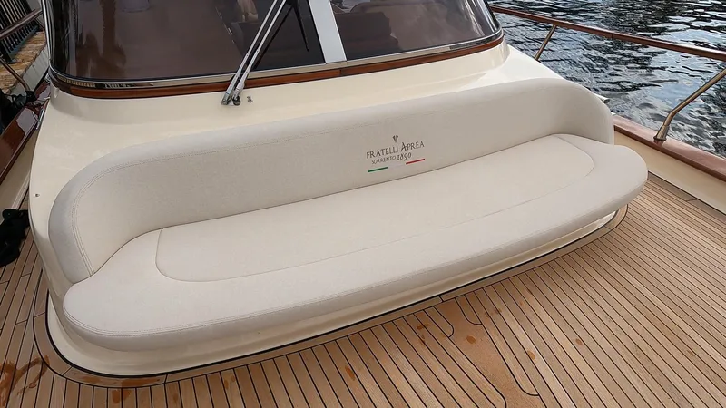 Fratelli Aprea Sorrento 32 Yacht Photos Pics Fratelli Aprea Sorrento Cabinatto 32, 2023 model, beige cushioned seating on wooden deck.