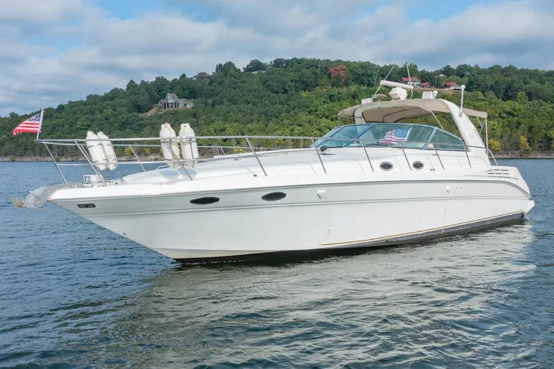 Just The Two Of Us Yacht Photos Pics 1997 Sea Ray 400 Sundancer yacht on a serene lake with lush green hills.
