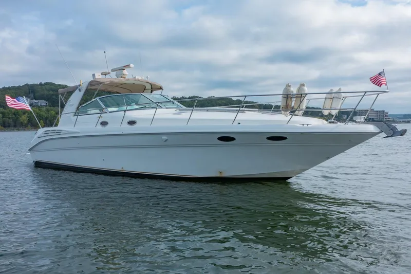 Just The Two Of Us Yacht Photos Pics 1997 Sea Ray 400 Sundancer yacht on calm water with American flags.