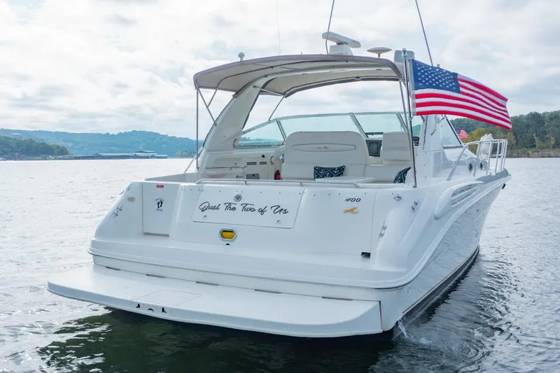 Just The Two Of Us Yacht Photos Pics 1997 Sea Ray 400 Sundancer yacht on water, American flag, scenic background.