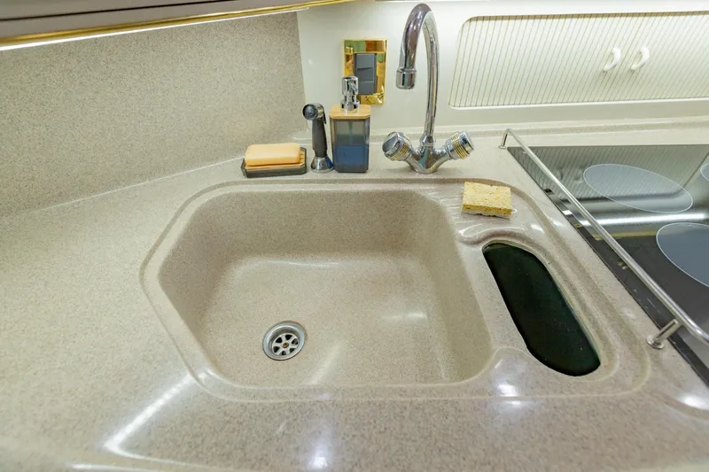 Just The Two Of Us Yacht Photos Pics Kitchen sink area in 1997 Sea Ray 400 Sundancer yacht, featuring faucet and countertop.