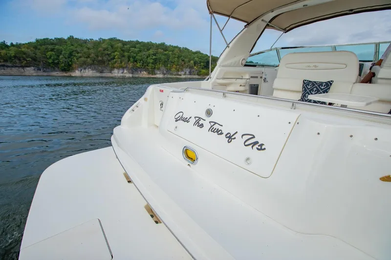 Just The Two Of Us Yacht Photos Pics 1997 Sea Ray 400 Sundancer yacht on serene water with lush green shoreline.