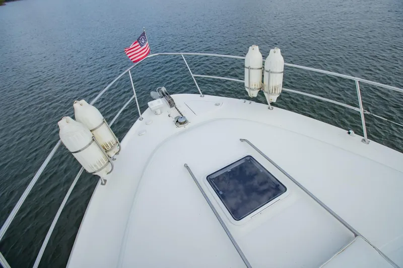 Just The Two Of Us Yacht Photos Pics 1997 Sea Ray 400 Sundancer yacht deck with American flag and fenders on calm water.