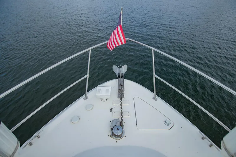 Just The Two Of Us Yacht Photos Pics Bow of 1997 Sea Ray 400 Sundancer with American flag on calm water.