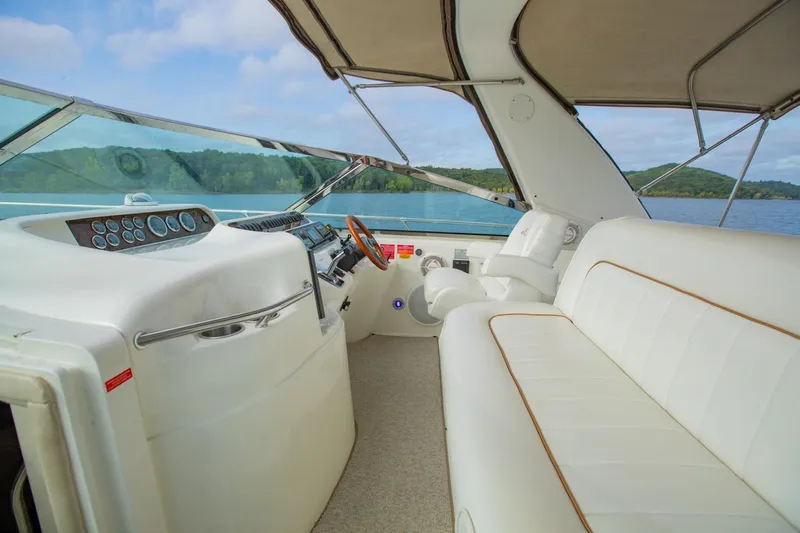 Just The Two Of Us Yacht Photos Pics 1997 Sea Ray 400 Sundancer yacht interior with white seating and helm, overlooking serene lake.