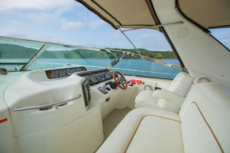 Just The Two Of Us Yacht Photos Pics 1997 Sea Ray 400 Sundancer cockpit with white leather seating and scenic lake view.