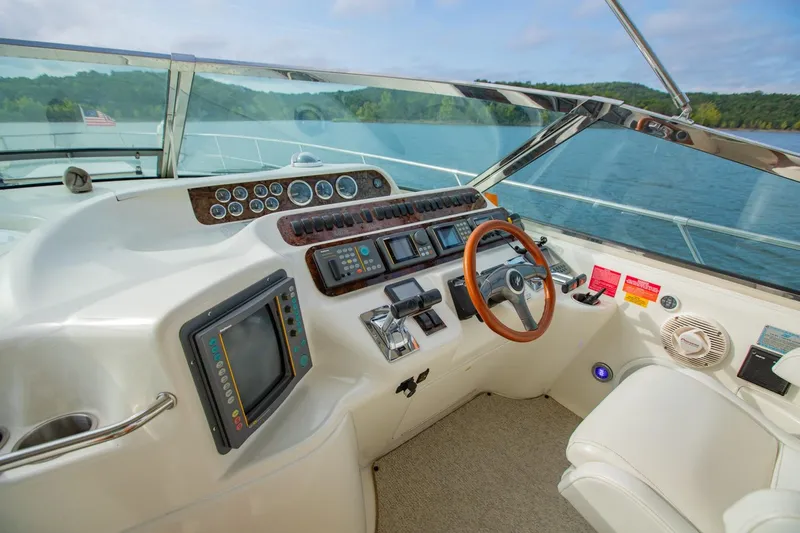 Just The Two Of Us Yacht Photos Pics 1997 Sea Ray 400 Sundancer helm with steering wheel, gauges, and navigation equipment.