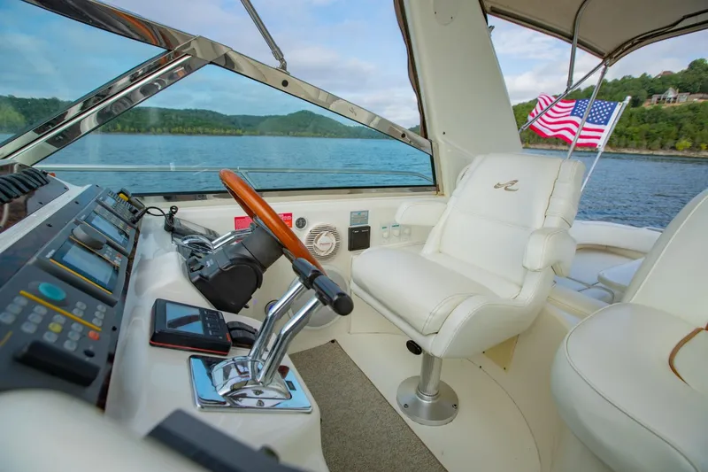 Just The Two Of Us Yacht Photos Pics 1997 Sea Ray 400 Sundancer helm with American flag, lake view, and luxurious seating.