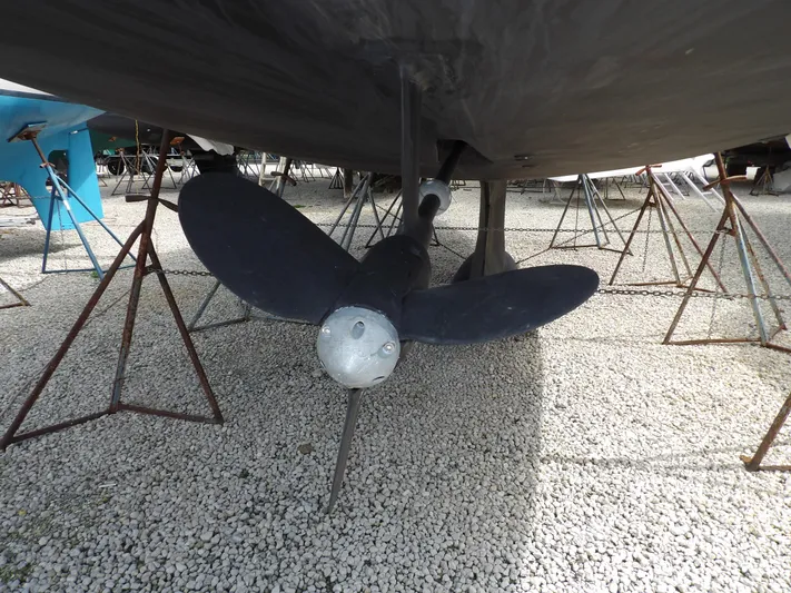 Summer Breeze Yacht Photos Pics Propeller of a 2000 Hunter 460 sailboat on a gravel surface.