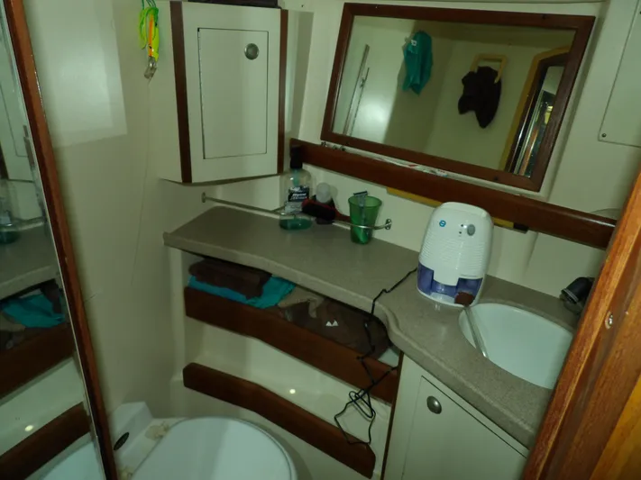 Summer Breeze Yacht Photos Pics Compact bathroom in a 2000 Hunter 460 sailboat with sink, mirror, and storage.