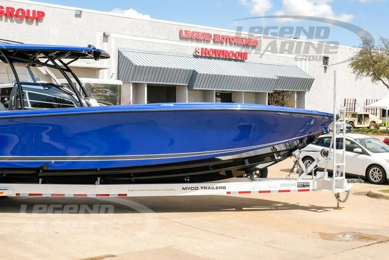  Yacht Photos Pics 2023 Nor-Tech 390 Sport Center Console in vibrant blue on trailer outside showroom.