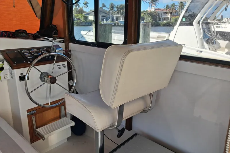Grey Dawn Yacht Photos Pics Interior of 1987 West Bay James Beal 31 Hardtop Lobster Boat with steering wheel and seat.