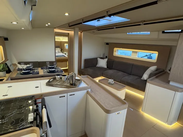  Yacht Photos Pics Luxurious interior of 2023 Beneteau First 53 yacht with modern kitchen and seating area.