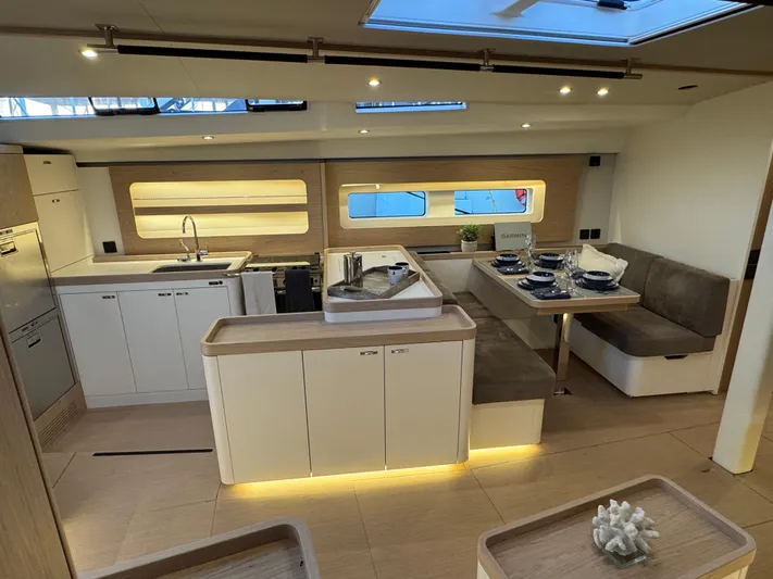  Yacht Photos Pics Luxurious interior of 2023 Beneteau First 53 yacht with modern kitchen and dining area.