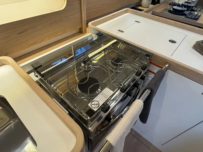  Yacht Photos Pics Modern kitchen in 2023 Beneteau First 53 yacht with sleek stove and cabinetry.
