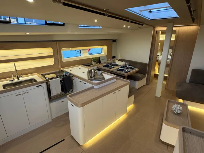  Yacht Photos Pics Luxurious interior of 2023 Beneteau First 53 yacht with modern kitchen and dining area.