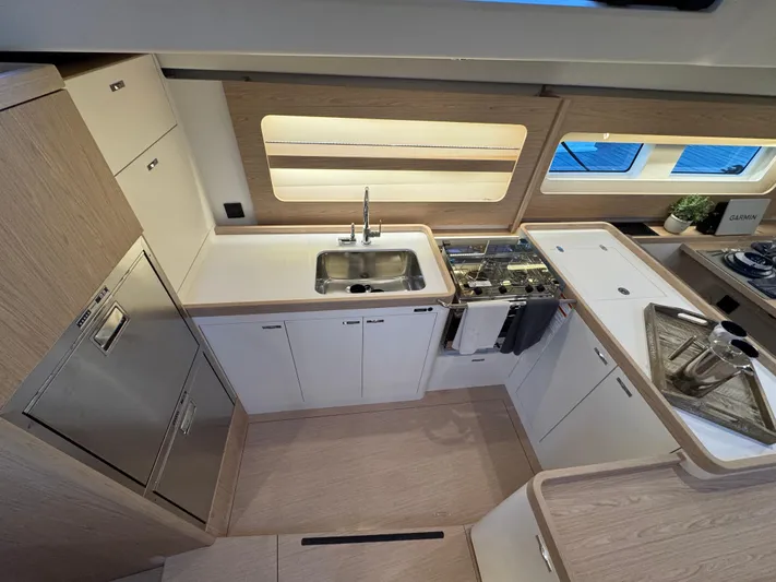  Yacht Photos Pics Modern kitchen interior of 2023 Beneteau First 53 yacht with sleek cabinetry and appliances.