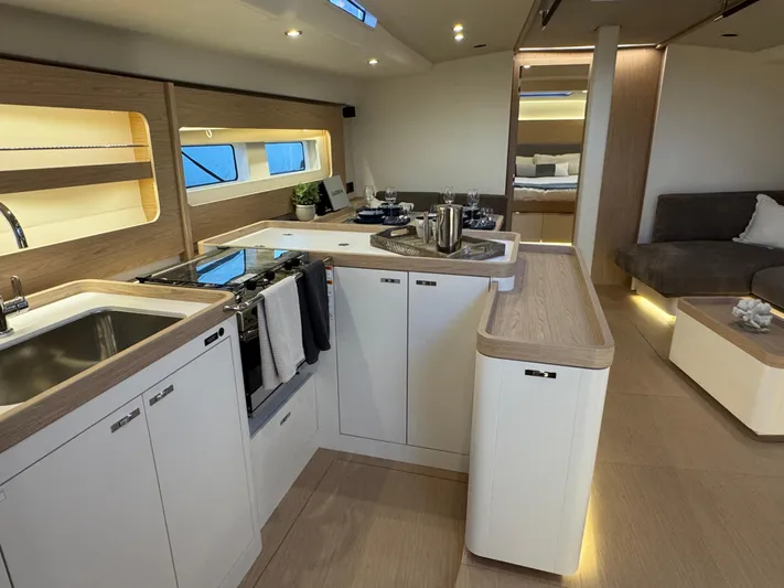  Yacht Photos Pics Luxurious interior of 2023 Beneteau First 53 yacht with modern kitchen and seating area.