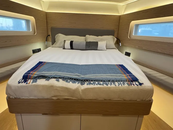  Yacht Photos Pics Luxurious cabin interior of 2023 Beneteau First 53 yacht with cozy bedding.