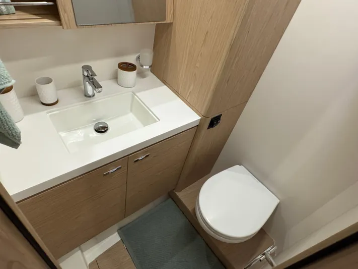  Yacht Photos Pics Modern bathroom in 2023 Beneteau First 53 yacht with sleek fixtures and wood cabinetry.