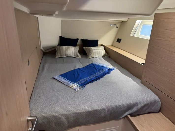  Yacht Photos Pics Luxurious cabin interior of 2023 Beneteau First 53 yacht with cozy bedding.