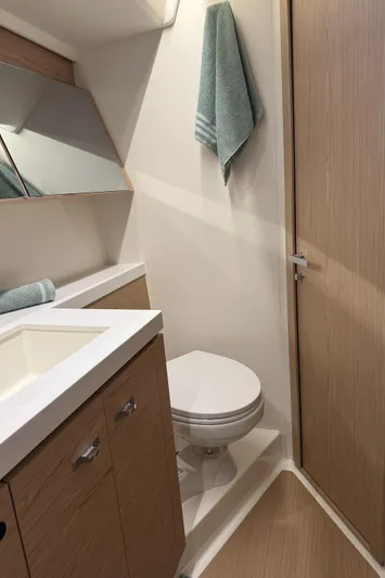  Yacht Photos Pics Modern bathroom in 2023 Beneteau First 53 yacht with sleek design and wood accents.