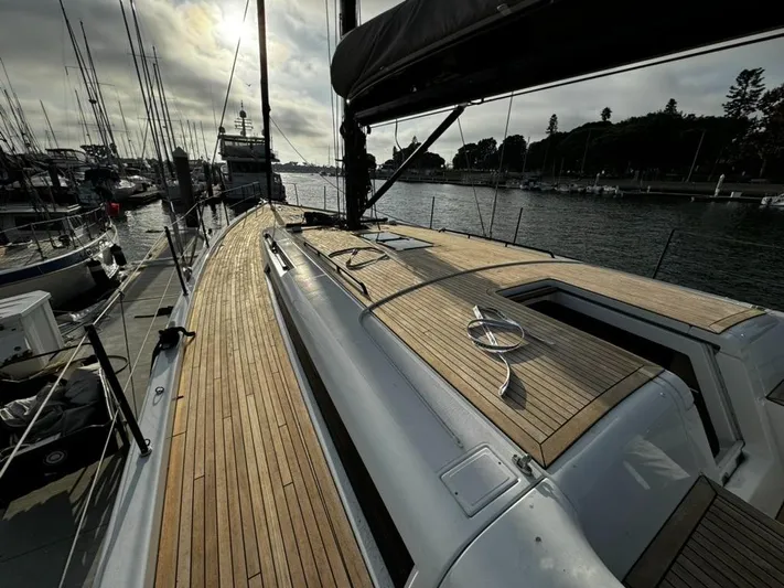  Yacht Photos Pics 2023 Beneteau First 53 yacht docked, showcasing sleek wooden deck and modern design.
